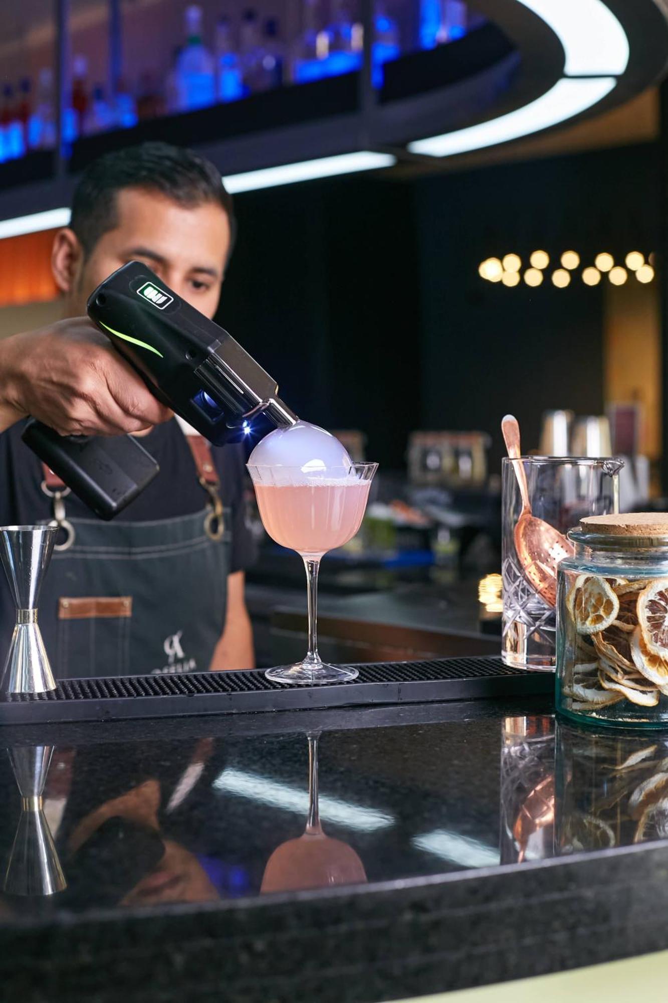 Pullman Santiago Vitacura Εξωτερικό φωτογραφία A bartender using a blowtorch to cook a cocktail